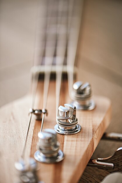 Photo gros plan de la poupée de guitare avec des touches pour ajuster les cordes de guitare