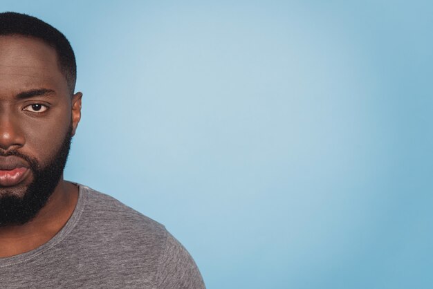 Photo photo en gros plan recadrée d'un homme américain en t-shirt sur fond bleu isolé