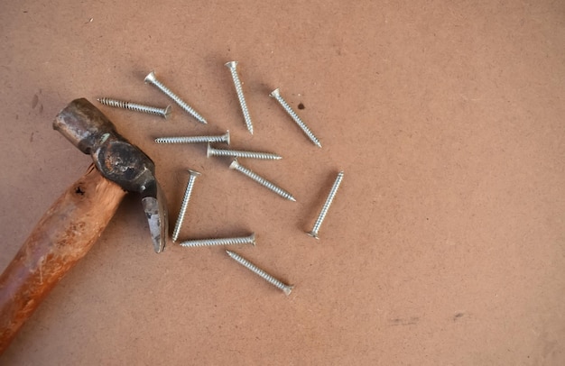 Une photo en gros plan d'une tête de marteau avec des clous ou des vis