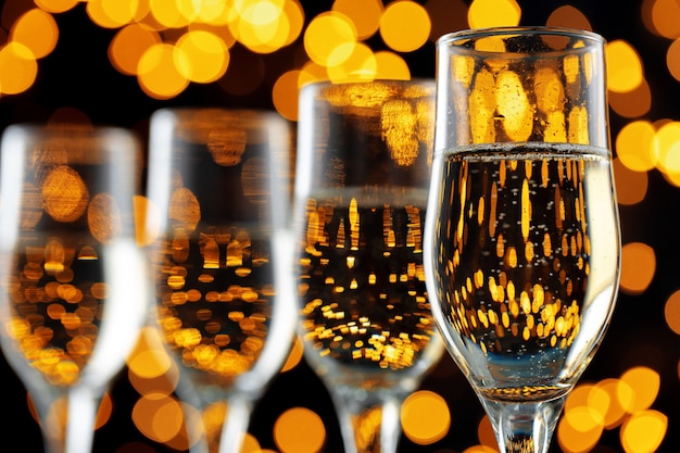 La photo en gros plan de verres à champagne contre les lumières bokeh