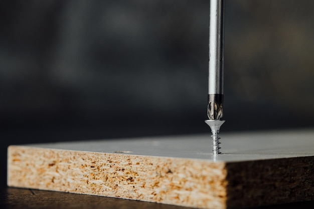 photo en gros plan de vis assorties pour l'assemblage de meubles sur la table en bois