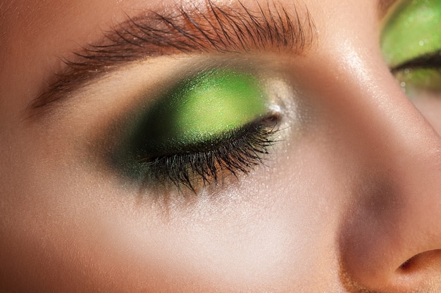 La photo en gros plan des yeux fermés avec du maquillage vert