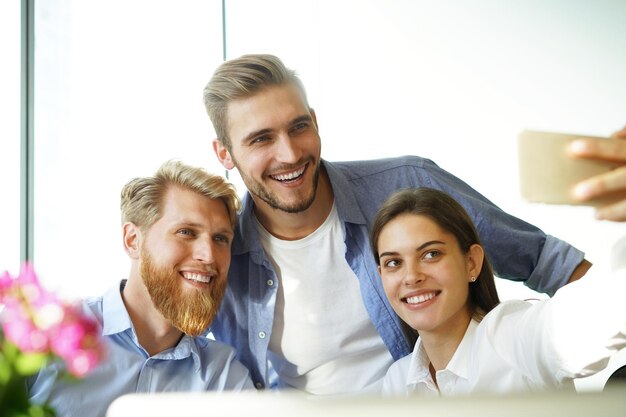 Photo de groupe de collègues s'amusant dans leur bureau.