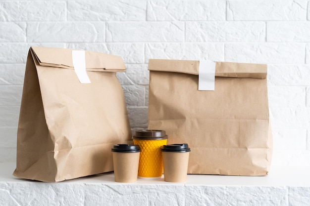Photo de groupe d'emballages alimentaires biodégradables et recyclables sur fond blanc, assiettes en papier, tasses, contenants, sacs, pas de logos.