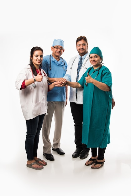 Photo de groupe de médecins asiatiques indiens montrant le succès ou le signe du pouce levé. debout isolé sur fond blanc. mise au point sélective