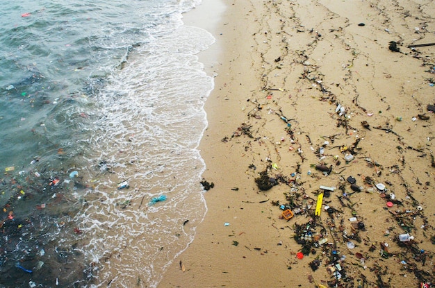 Une photo haute-angle d'une plage pleine de déchets