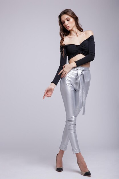 Photo haute couture d'une belle jeune femme élégante dans un joli pantalon argenté, pantalon, haut noir