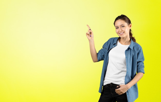 Photo de heureuse jeune femme debout montrant la surface pointée