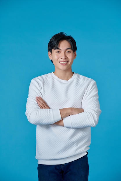 Photo d'un homme d'affaires asiatique debout avec les bras croisés et souriant