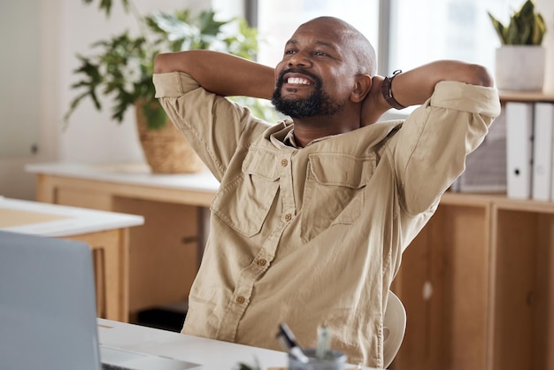 Photo d'un homme d'affaires mature se relaxant à son bureau dans un bureau moderne