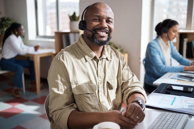 Photo d'un homme d'affaires mature utilisant un casque dans un bureau moderne avec son collègue travaillant en arrière-plan