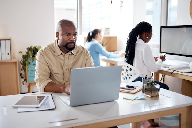 Photo photo d'un homme d'affaires mature utilisant un ordinateur portable dans un bureau moderne