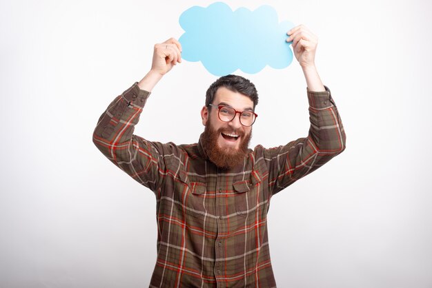 Photo d'un homme barbu heureux dans des verres tenant des nuages au-dessus de sa tête