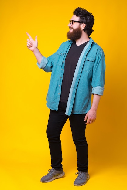 Photo d'un homme barbu joyeux qui montre du doigt.