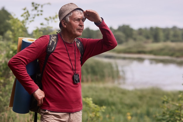 Photo d'homme caucasien homme hipster avec sac à dos et tapis dans la nature