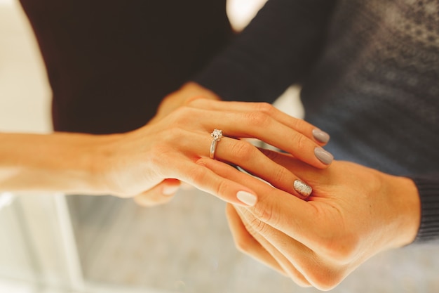 Photo d'un homme et d'une femme avec une alliance, les jeunes mariés choisissent et achètent une alliance dans une bijouterie.