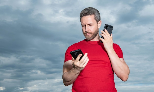 Photo d'un homme occupé a une conversation téléphonique l'homme a une conversation téléphonique sur fond de ciel