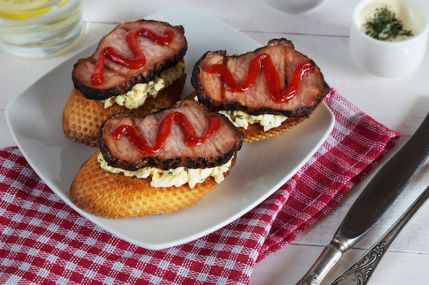 Une photo horizontale de deux sandwiches au jambon et au ketchup