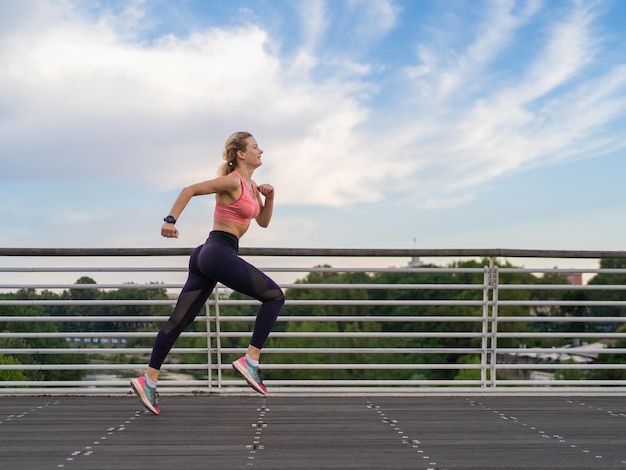 Photo horizontale d'une femme forte courant dans le concept de remise en forme de l'espace de copie de la ville