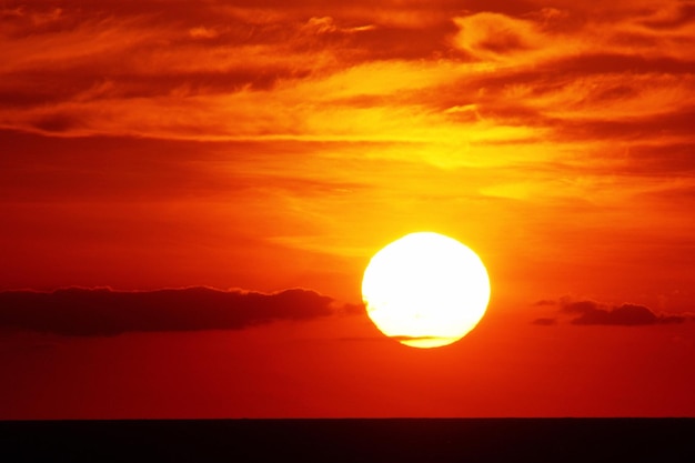 Une photo idyllique du soleil sur un ciel orange.