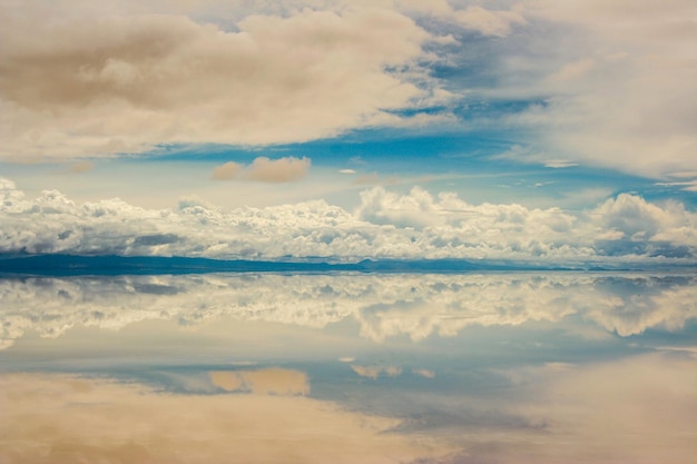 Une photo idyllique des nuages se reflétant dans l'eau au salar de uyuni