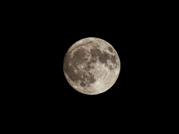 Une photo idyllique de la pleine lune contre le ciel