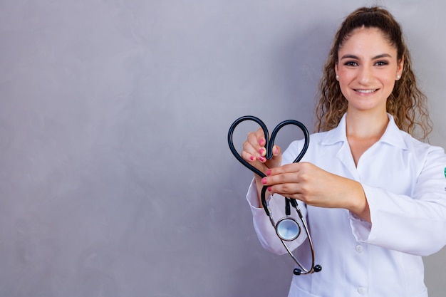 Photo d'infirmière tenant un stéthoscope sur fond gris