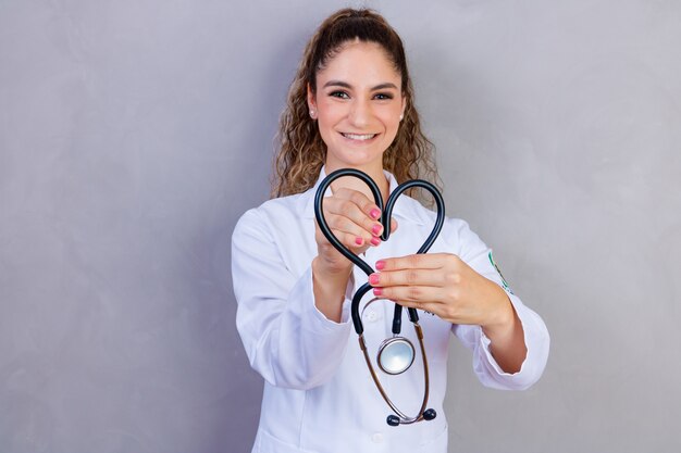 Photo d'infirmière tenant un stéthoscope sur fond gris