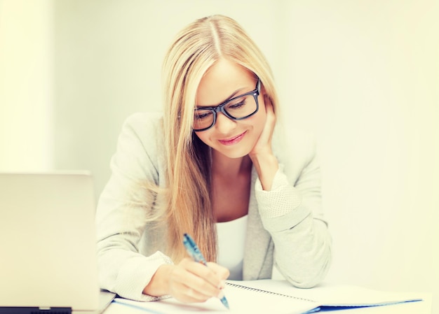 photo intérieure d'une femme souriante avec des documents et un stylo