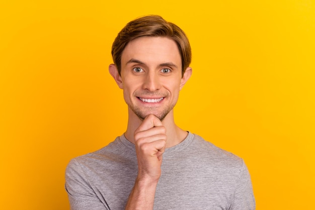 Photo de jeune beau mec heureux sourire positif toucher la main menton rêve pense isolé sur fond de couleur pastel