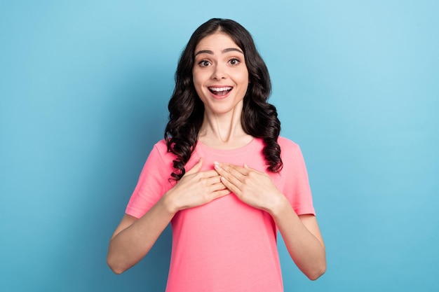 Photo de jeune belle femme excitée mains sur la poitrine réaction reconnaissante isolée sur fond bleu