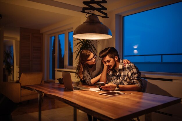 Photo d'un jeune couple calculant ses finances à la maison