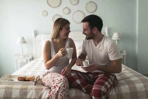 Photo d'un jeune couple heureux passant la matinée ensemble dans la chambre