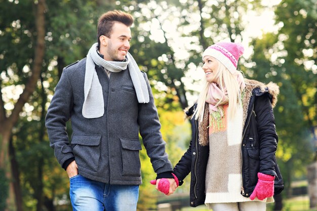 Une photo d'un jeune couple marchant dans le parc