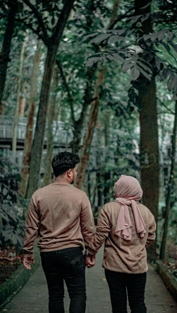 photo d'un jeune couple en pulls bruns dans un jardin