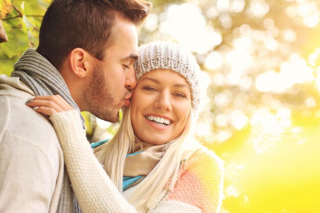 Une photo d'un jeune couple romantique s'embrassant dans le parc en automne