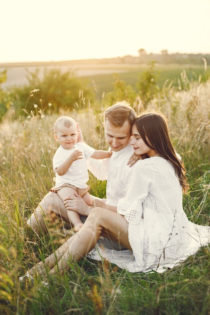 Photo d'une jeune famille assise sur le terrain par une journée ensoleillée.