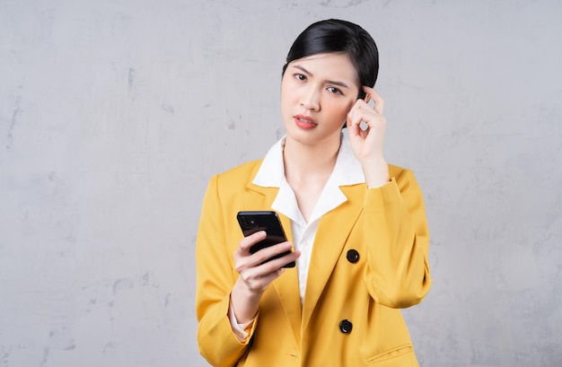 Photo d'une jeune femme d'affaires asiatique tenant un téléphone