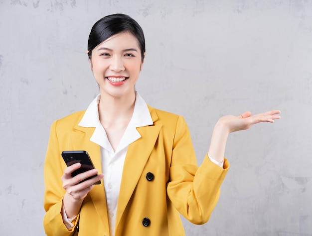 Photo d'une jeune femme d'affaires asiatique tenant un téléphone