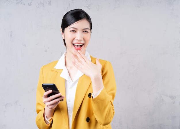 Photo d'une jeune femme d'affaires asiatique tenant un téléphone