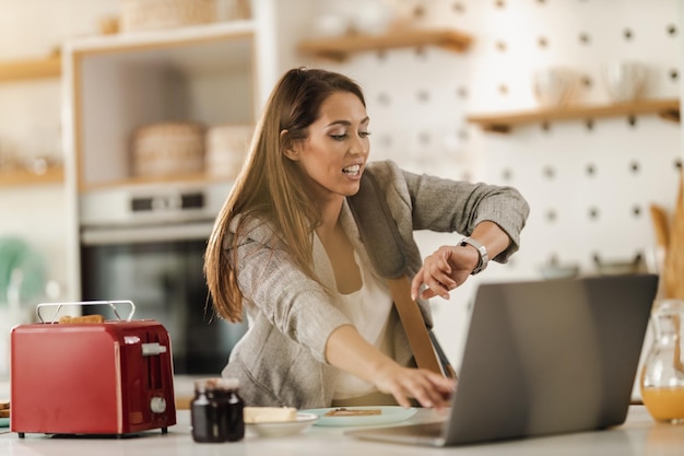 Photo d'une jeune femme d'affaires multitâche regardant sur la montre et vérifiant votre emploi du temps pour cette journée tout en se préparant à aller travailler.