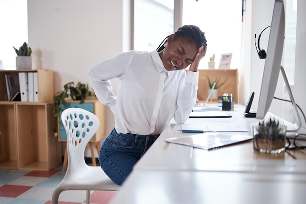 Photo d'une jeune femme d'affaires souffrant de maux de dos alors qu'elle travaillait à son bureau dans un bureau moderne