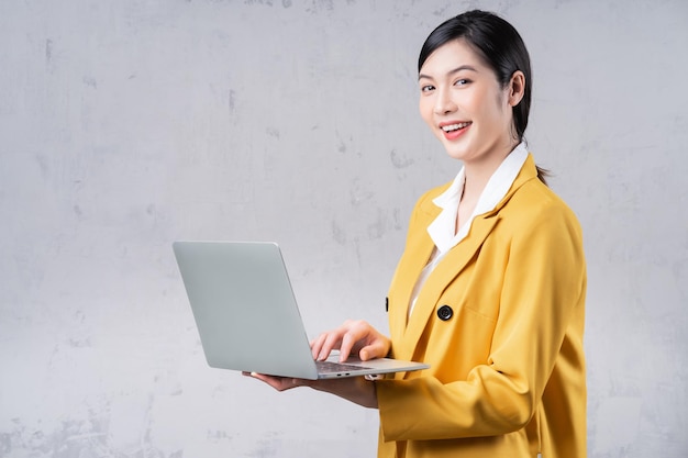 Photo d'une jeune femme asiatique tenant un ordinateur portable