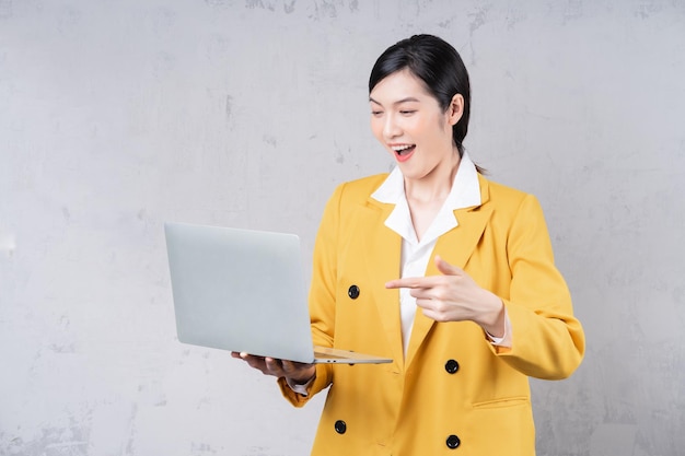 Photo d'une jeune femme asiatique tenant un ordinateur portable