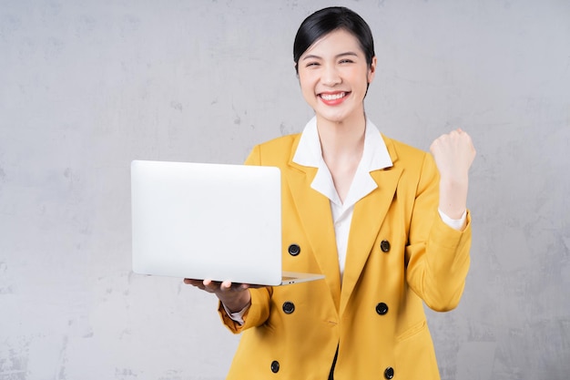 Photo d'une jeune femme asiatique tenant un ordinateur portable