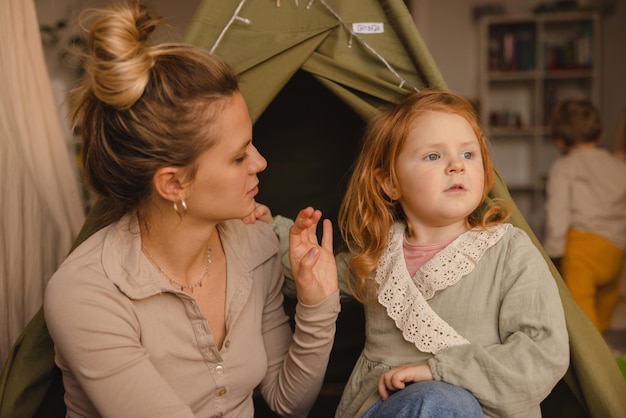 En photo jeune femme blonde caucasienne avec sa petite fille rousse de 23 ans à l'intérieur concept de maternité