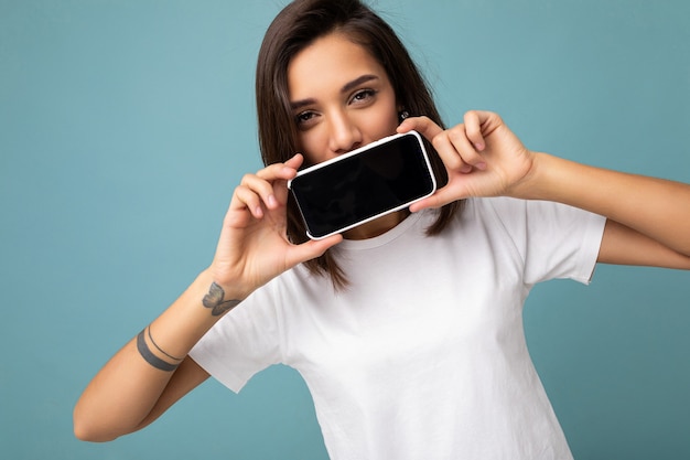 Photo D'une Jeune Femme Brune Assez Positive à La Recherche De T-shirt Blanc Debout Isolé Sur