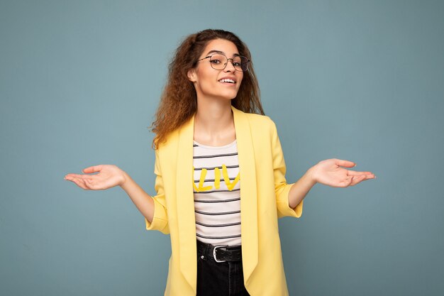 Photo de jeune femme brune bouclée réfléchie positive avec des émotions sincères portant