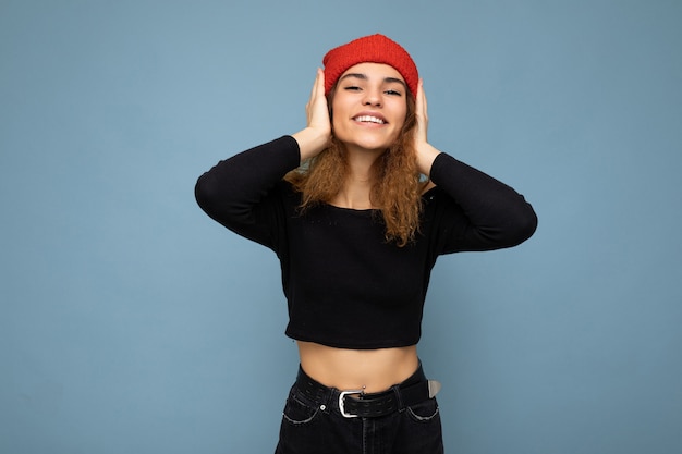 Photo d'une jeune femme brune séduisante souriante et souriante aux cheveux ondulés avec des émotions sincères portant