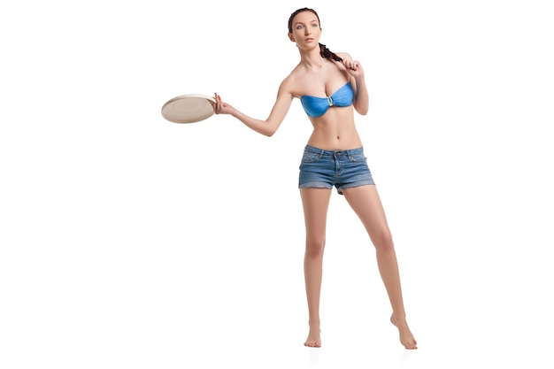 Photo photo de jeune femme heureuse jouant avec un disque volant sur fond blanc